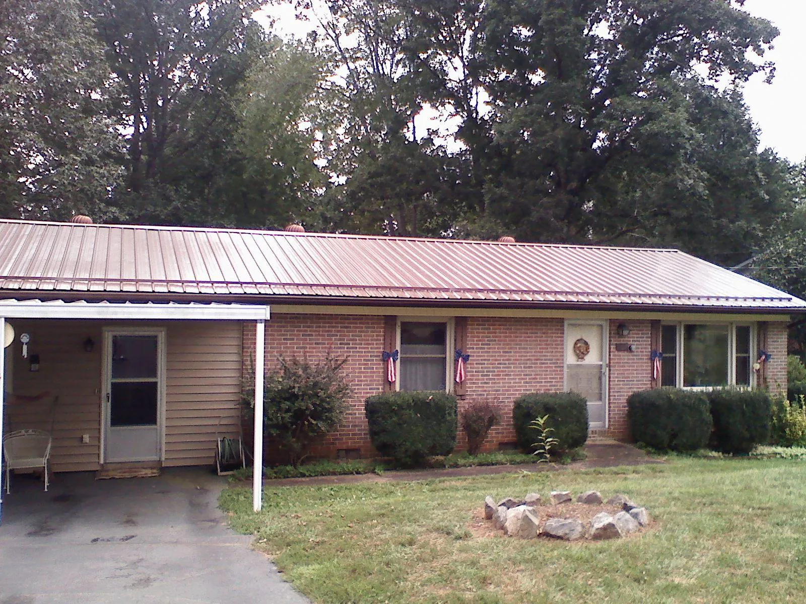 Bronze metal roof and carport on a brick ranch home — Roof Repair work by our crew in Mahopac
